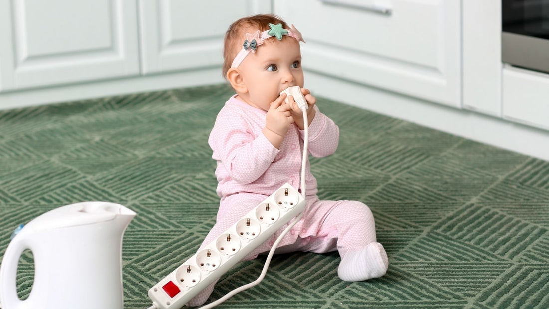 Baby die aan stopcontact knabbelt in de keuken