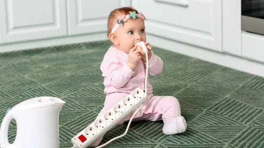 Baby die aan stopcontact knabbelt in de keuken